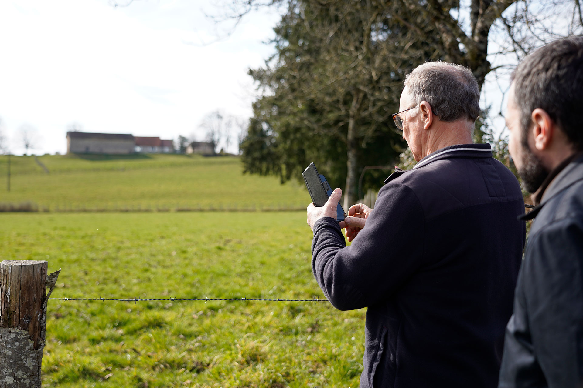 Photo d'un agriculteur qui teste sur son smartphone l'application Photos Géolocalisées